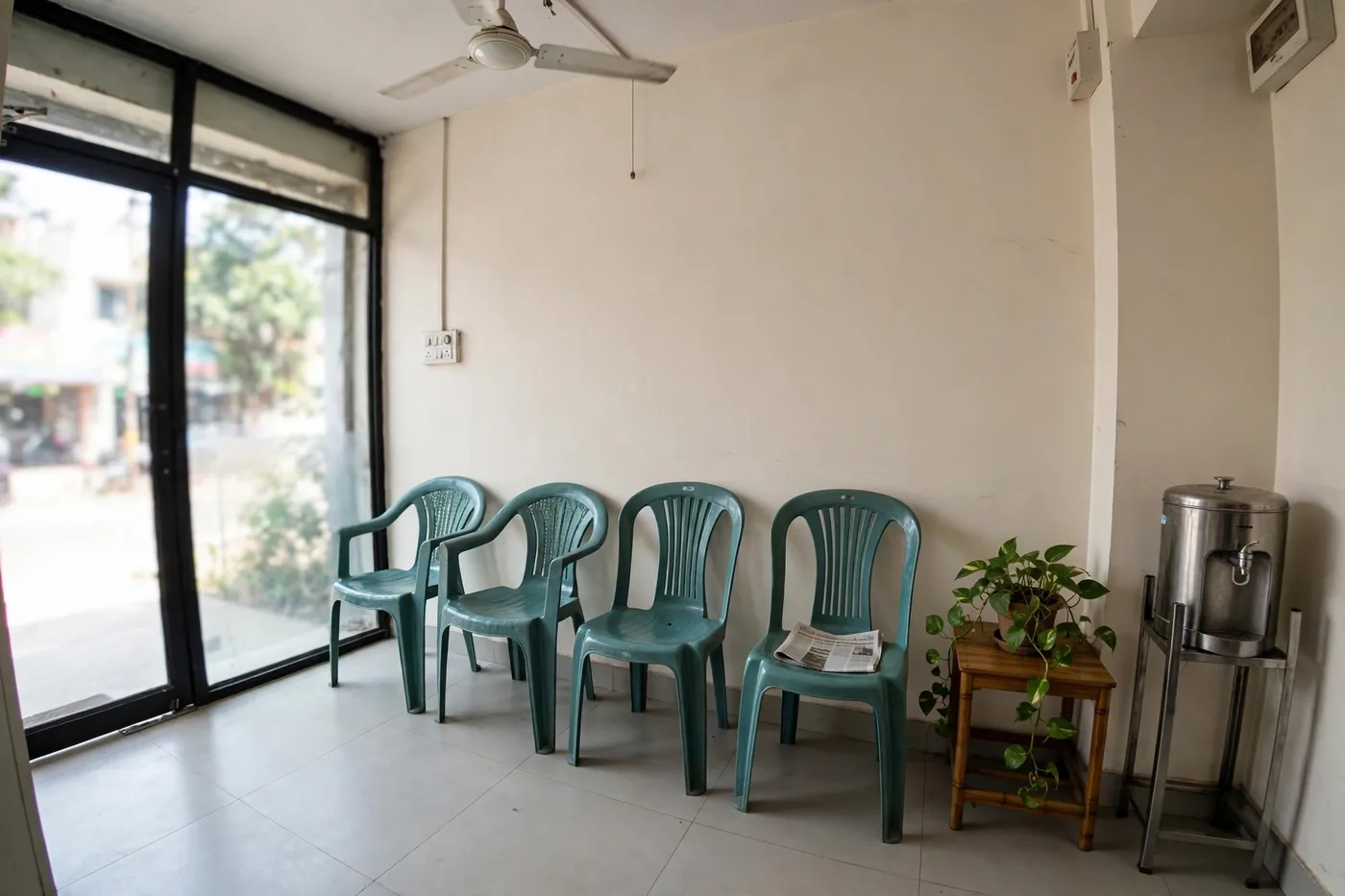 The waiting corner — Chairs, the day's newspaper, water, and the money plant.